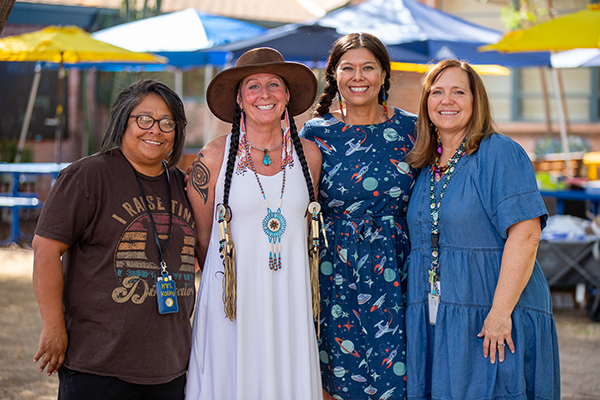 Four women smile for a group photo
