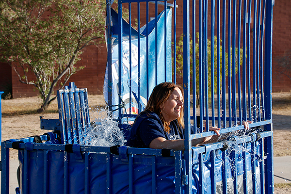 A woman laughs as she falls into the dunk tank
